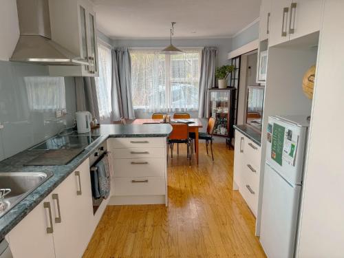 a kitchen with white appliances and a dining room at Mid-Century Peace in a Prime Location in Auckland