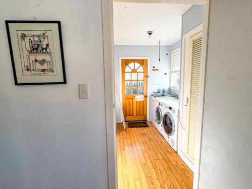 a hallway of a home with a washing machine at Mid-Century Peace in a Prime Location in Auckland