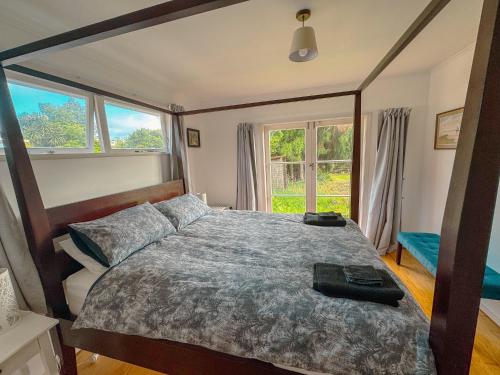 a bedroom with a large bed with a large window at Mid-Century Peace in a Prime Location in Auckland
