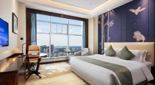 a bedroom with a large bed and a large window at Ramada by Wyndham Wuhan Dongxihu in Wuhan