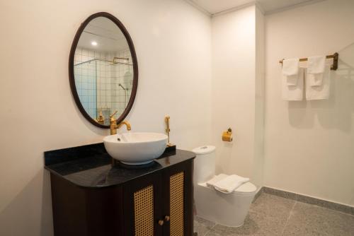a bathroom with a sink and a mirror and a toilet at The Green Hotel Vientiane in Vientiane