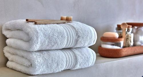 a stack of towels on a shelf in a bathroom at Chic & Modern Apartment In The Heart Of Downtown in Victoria