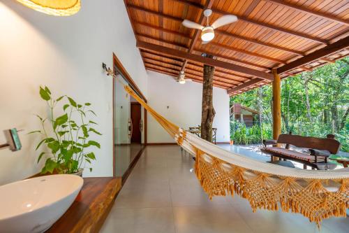 a room with a hammock in a house at Casa alto padrão próximo a praia, suíte, jacuzzi in Marau