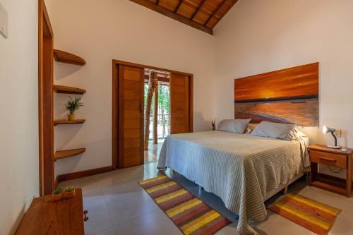 a bedroom with a bed with a wooden headboard at Casa alto padrão próximo a praia, suíte, jacuzzi in Marau