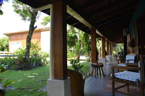 a porch of a house with chairs and a table at Casa da Ilha do Mel - Pousada de Charme in Ilha do Mel
