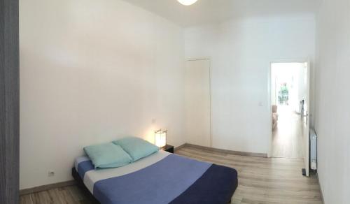 une chambre avec un lit avec des oreillers bleus dessus dans l'établissement Appartement Nice Centre, à Nice