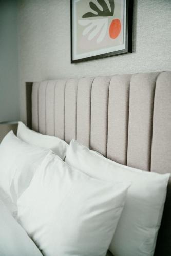 a bed with white pillows and a picture on the wall at Urban Elegance: Luxury; Sleeps 6 in Belfast