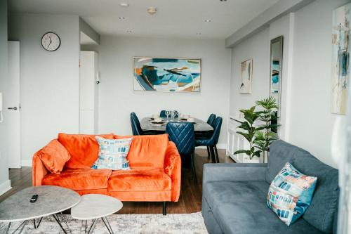 a living room with an orange couch and a table at Urban Elegance: Luxury; Sleeps 6 in Belfast