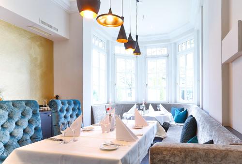 a dining room with long tables and blue chairs at Holzapfel in Bad Füssing