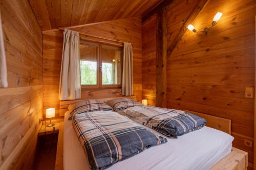 een bed in een blokhut met een raam bij Koanzhaus, Troadkasten in Franking