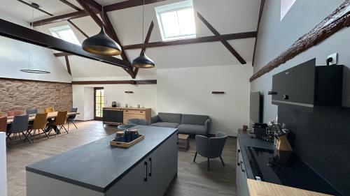 a kitchen and living room with a couch and a table at Les 4 Fontaines in Osenbach
