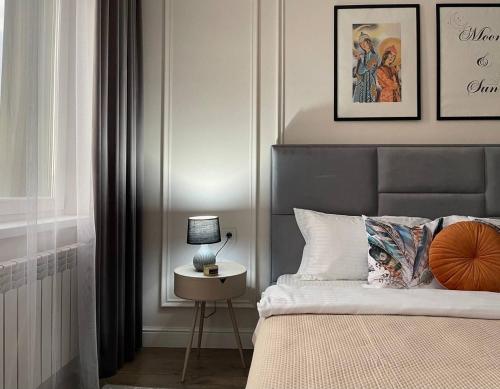 Un dormitorio con una cama y una mesa con una lámpara. en Экспо апарт 176, en Astana