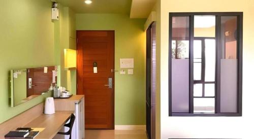 ein Badezimmer mit einer Tür, einem Waschbecken und einem Spiegel in der Unterkunft Na Tubthieng Boutique Resort Trang in Ban Phlu Phli