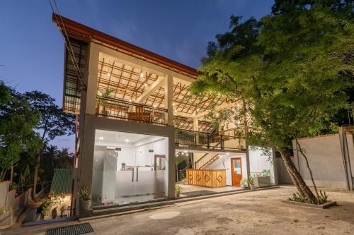 ein Haus mit einer Garage und einem Baum in der Unterkunft Arice Eco Villa and Restaurant Unawatuna in Galle
