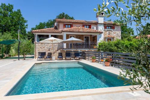 a villa with a swimming pool in front of a house at House Matija in Svetvinčenat