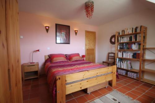 a bedroom with a bed and a book shelf at Au Paradis des 4 Saisons in Héric