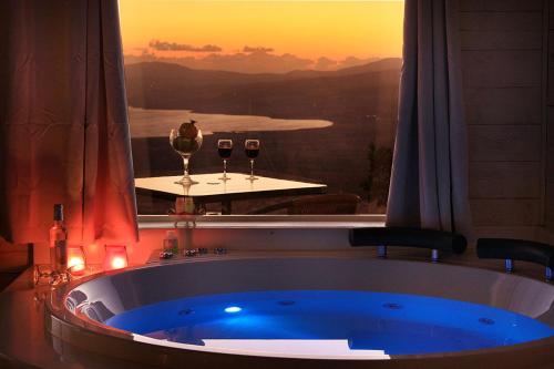 Una bañera con dos copas de vino en una habitación. en נופי גמלא, en Ma'ale Gamla