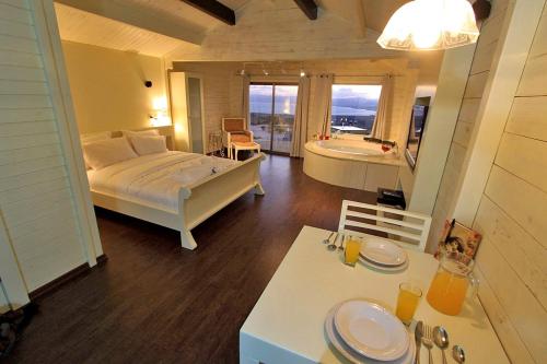 Un dormitorio con una cama y un baño con bañera. en נופי גמלא, en Ma'ale Gamla