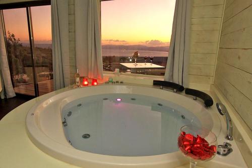 a large bath tub in a room with a window at נופי גמלא - 2 סוויטות מדהימות ונעימות לזוגות במעלה גמלא in Ma'ale Gamla
