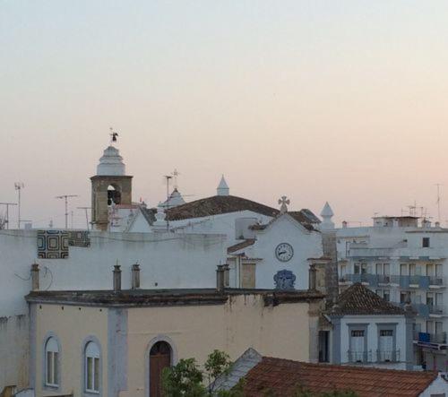 a building with a clock tower on top of it at EntreCubos Guesthouse in Olhão