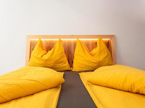 two beds with yellow pillows sitting next to each other at Apartment Wiesbachhorn Zell am See-Kaprun in Kitzsteinhorn