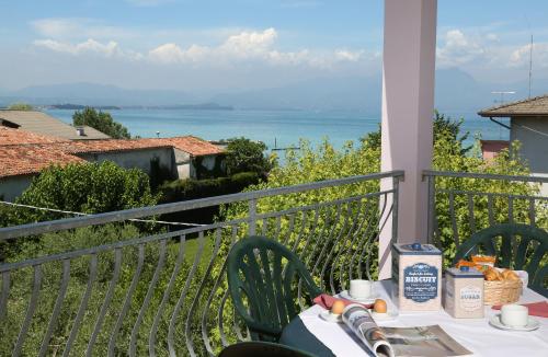 a table on a balcony with a view of the ocean at Nettuno Residence Hotel in Peschiera del Garda