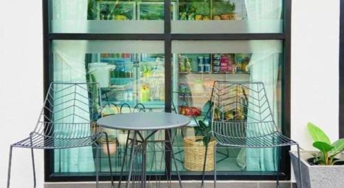 a table and chairs in front of a window at The Hub Hotel Surin in Surin