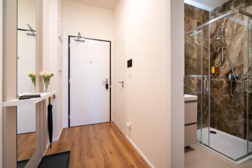 a bathroom with a shower and a glass door at apartino - FREE parking - Novostavba - Omezený přístup a stavební ruch - New Building - Limited Access and Construction noise in Komárov