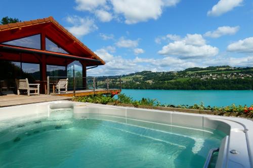 a swimming pool with a view of a lake at SEEBLICK romantic chalet spa lake view in Paladru