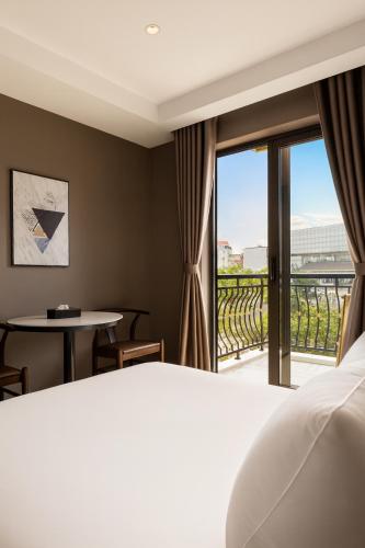 a hotel room with a bed and a balcony at Orange Crystal Phoenix hotel in Bắc Ninh