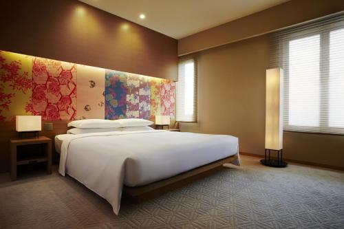 a bedroom with a large white bed and a window at Hyatt Regency Kyoto in Kyoto