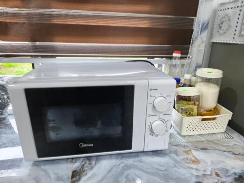 a microwave sitting on top of a counter at AF Barokah Homestay Unit 2 , Kuala Terengganu in Kuala Terengganu