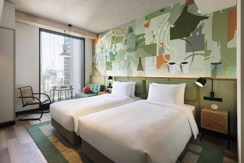 東京にあるCaption By Hyatt Kabutocho Tokyoの壁画のあるホテルルーム内のベッド2台