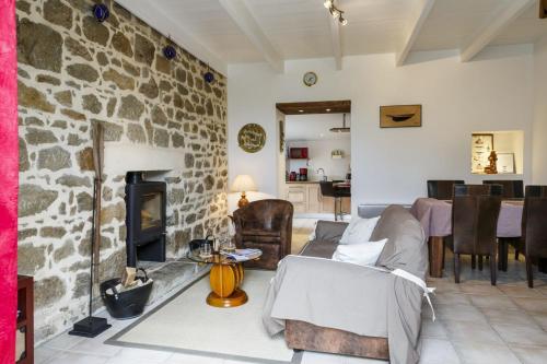 een woonkamer met een stenen open haard en een bank bij La fringante in Pleubian