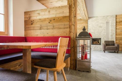 a dining room with a table and a red couch at Hotel Panorama in Fleres