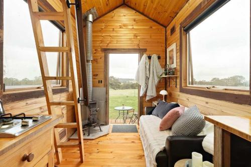 ein Wohnzimmer eines Minihauses mit einer Leiter in der Unterkunft Hillsview Cottage by Tiny Away in Taradale