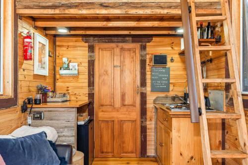 a kitchen with a counter and a ladder in a cabin at Hillsview Cottage by Tiny Away in Taradale