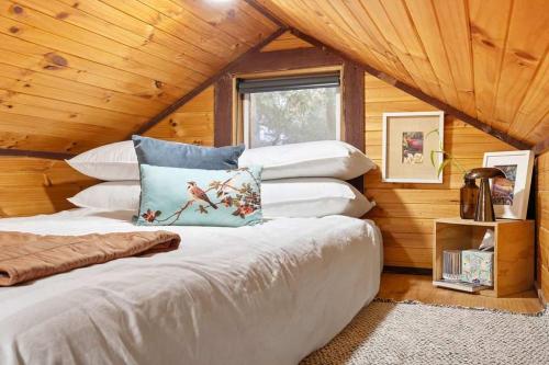 a bedroom with a large bed in a log cabin at Hillsview Cottage by Tiny Away in Taradale