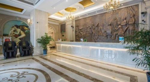 a lobby of a hotel with a painting on the wall at Vienna International Shanghai Nanxiang in Chenjiahang