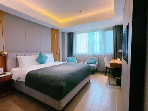 a hotel room with a large bed and a desk at Yitel Collection Shenyang North Railway Station Metro Station in Shenyang
