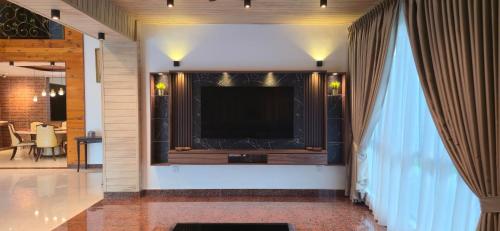 a living room with a large television on a wall at Gasing WheelHouse in Petaling Jaya