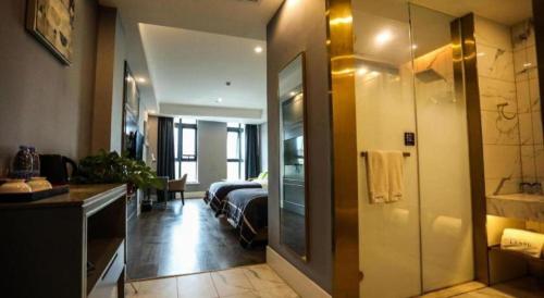 een kamer met een bed en een badkamer met een spiegel bij LANO Hotel Anhui Suzhou Yongqiao District Yingbin Avenue in Suzhou