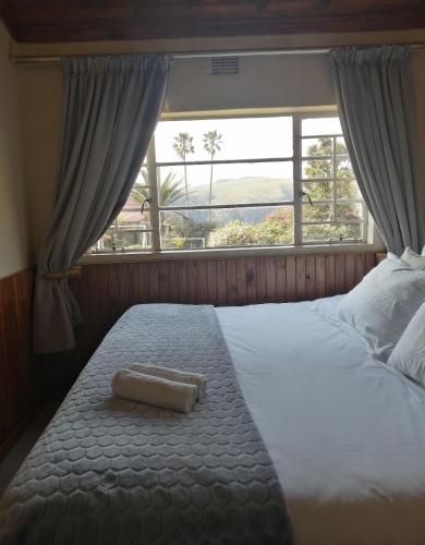 a bed with a towel on it in front of a window at Panorama home 19 in Graskop