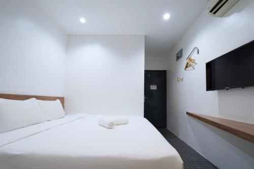 Un dormitorio con una cama y un televisor de pantalla plana. en T Hotel Kuala Perlis, en Kuala Perlis