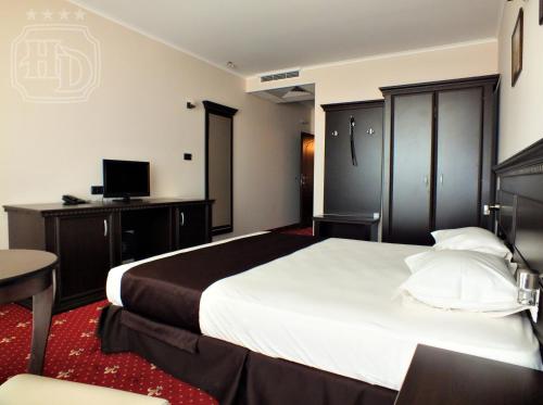 a hotel room with a large bed and a television at Hotel Dragalevtsi in Sofia