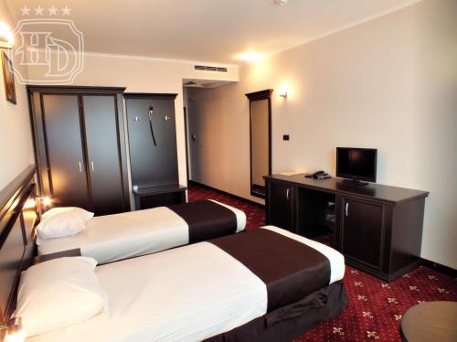 a hotel room with two beds and a desk at Hotel Dragalevtsi in Sofia