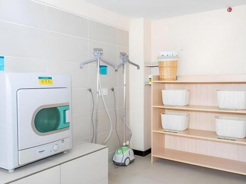 een kamer met een tv en een wasmachine bij City Comfort Inn Beiliu Bus Terminal in Beiliu