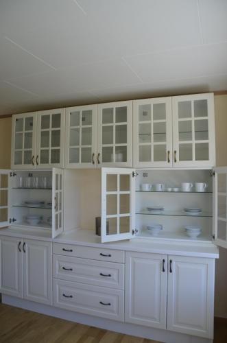 a kitchen with white cabinets and white counters at Fjord House in Fornes