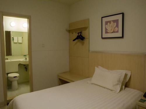 een slaapkamer met een bed, een wastafel en een toilet bij Jinjiang Inn Shanghai Qingpu in Qingpu