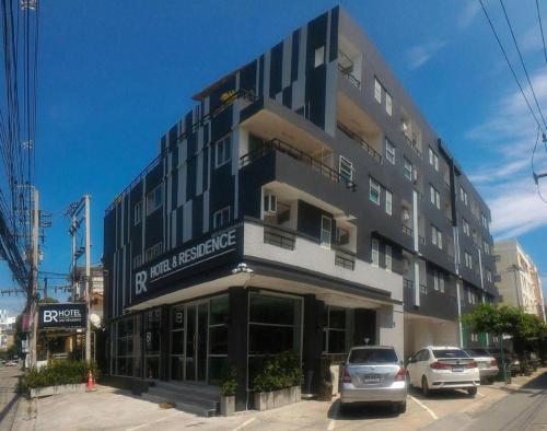 a large building with cars parked in front of it at BR Hotel & Residence (Parking is available 250 meters away from the property) in Ban Rong Khoei